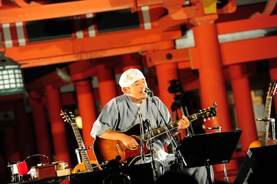 嚴島神社の祓殿をバックに熱唱する民生。