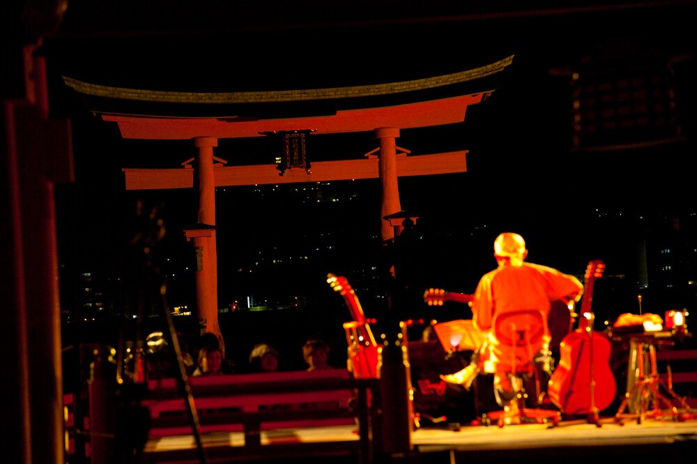 神妙な表情でダブルピースを掲げる民生。 - 奥田民生、嚴島神社奉納