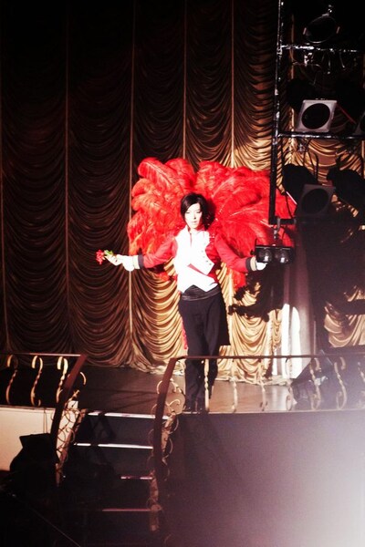 薔薇色の羽根を背負ってステージに登場した傷彦。（写真：佐々木宏幸）