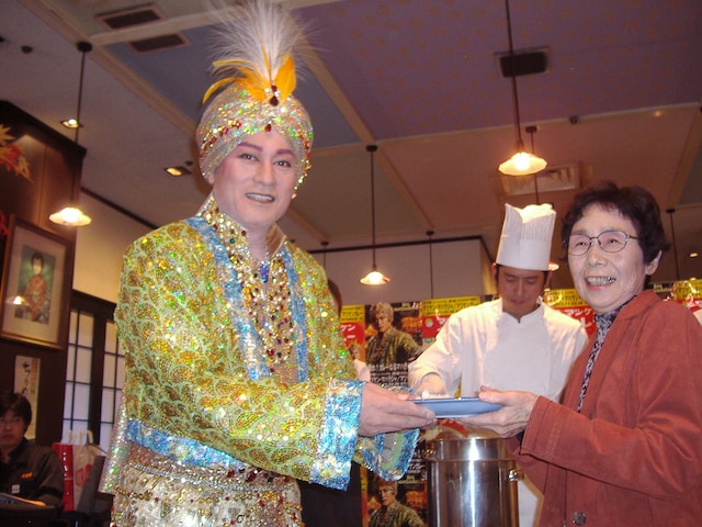 ド派手な衣装とメイクのままファンにカレーをふるまうマツケン。