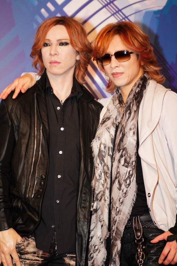 報道陣のリクエストに応じ、フィギュアと肩を組んで撮影に臨むYOSHIKI。(C)マダム・タッソー