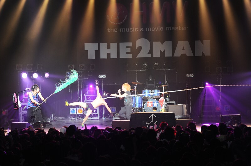 「抱きしめてシュヴァルツ」での“ギターソロ”の様子。鎖の長さが足りず宙に舞う喜矢武豊（写真左から2人目）。