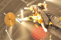 黒子に支えられてシンバルキックを披露する綾小路翔（撮影：小川舞）。