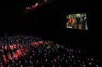 スクリーンでUFI登場の趣旨説明をする「＠川島プロダクション」の面々。彼らはこの後ステージにも姿を現した。