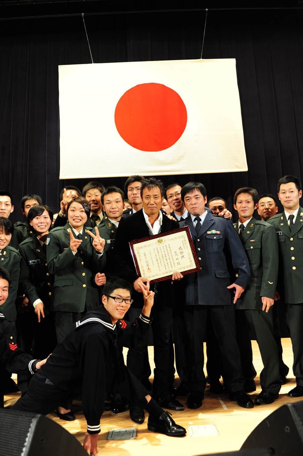 感謝状を手に、自衛隊員たちと記念撮影する長渕剛。