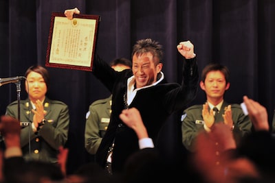 感謝状を受け取りガッツポーズする長渕剛。