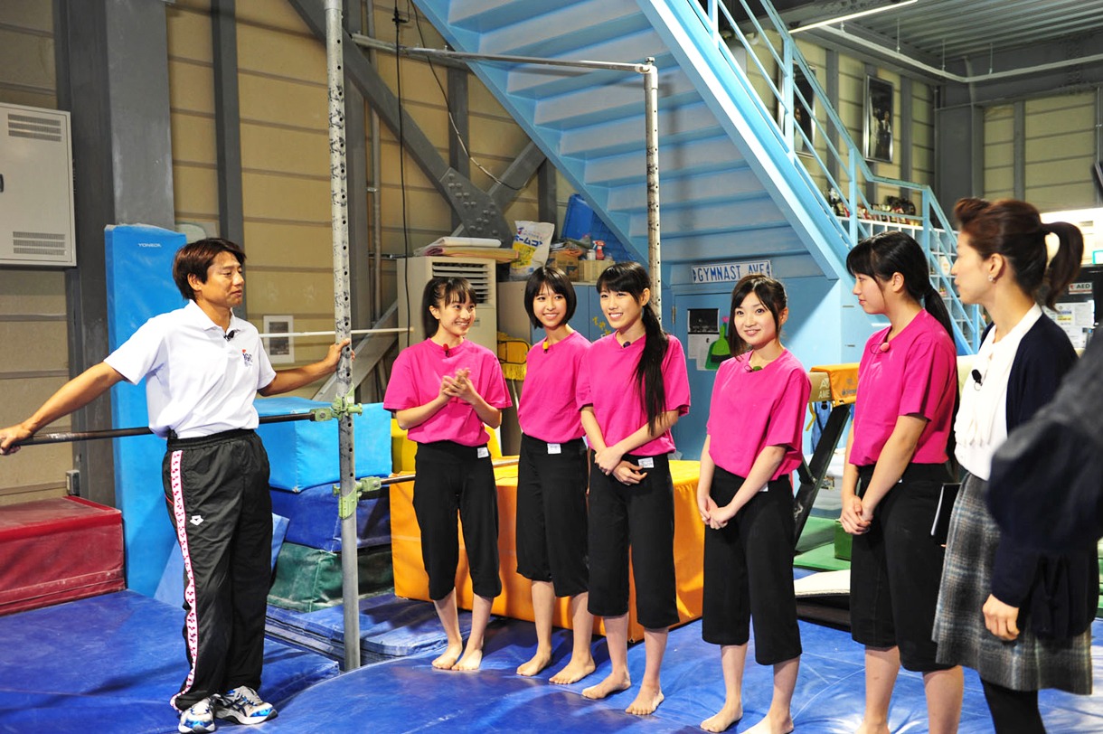 鉄棒の基礎を教える池谷幸雄（写真左端）。