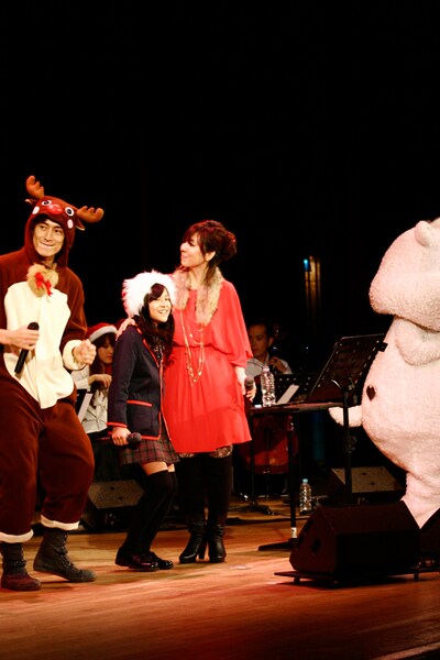 写真は「飯舘村卒業式イベント」の様子。トナカイに扮した伊勢谷友介（写真左）とクリスマスカラーの衣装で登場した岡本真夜（中央）。