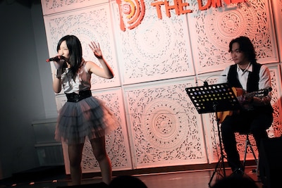 ボサノバ調にアレンジされた「Bomb a Head!」を歌う小西彩乃（写真左）。