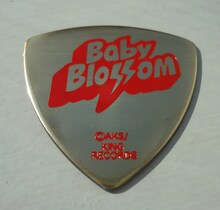 大島優子モデルのギターピックは、「Baby Blossom」の赤文字が印象的なデザイン。裏面には大島のサインが記されている。