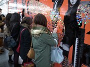 ギターピックに気付き、大型ポスターに集まる通行人。