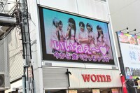 13:00に三角公園前の街頭ビジョンで放映された告知映像より。「（タコ焼きを）今から食べ行っちゃう？」と大阪に行くことを匂わせた。