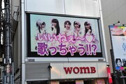 14:00に三角公園前の街頭ビジョンで放映された告知映像より。「歌っちゃう？」とライブを行うことを匂わせた。