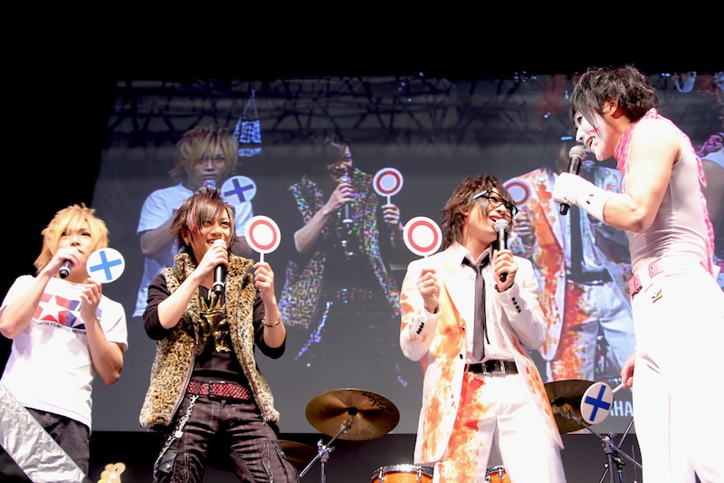 くじ引きの結果を互いに見せ合うメンバー4人。