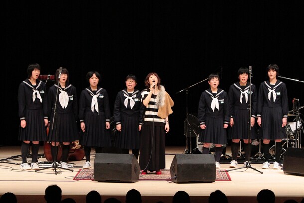 地元中学校の女子生徒らをコーラスに従えて歌うたむらぱん。