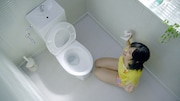 写真は花王「トイレクイックル」新CM「1枚でおそうじ体験」編より。夢中でトイレ全体をきれいにするさしこ。