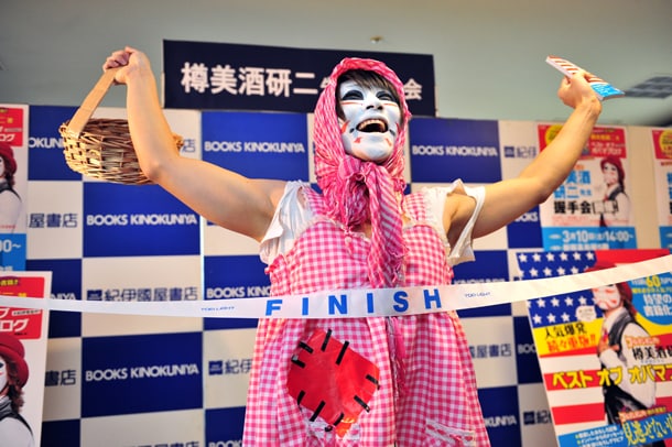 白い歯を輝かせ、満面の笑顔でゴールテープを切る樽美酒研二。