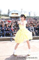 会場のファンを背に、ハートを撃ち抜くポーズを取るまゆゆ。