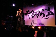 力強く書かれた「やるなら今」という文字の前で熱唱する若旦那