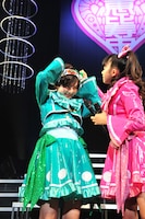 自己紹介のためにハチマキを巻く安本彩花。手伝う星名美怜。