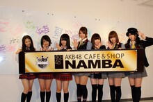 「AKB48 CAFE & SHOP NAMBA」をアピールするAKB48＆NMB48メンバー。写真左から小鷹狩佑香、城恵理子、山本彩（以上NMB48）、高城亜樹、片山陽加、小林香菜、前田亜美（以上AKB48）。 (C)AKS