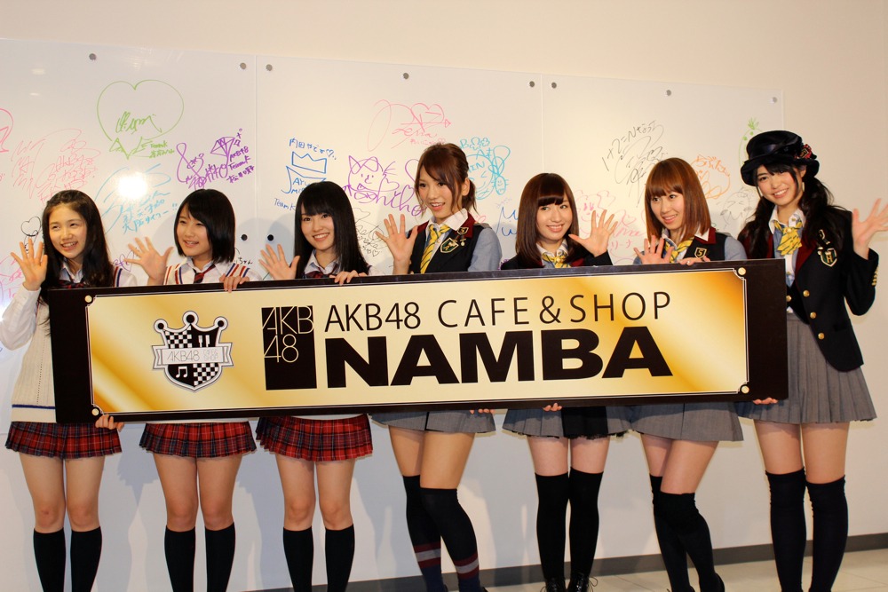 「AKB48 CAFE & SHOP NAMBA」をアピールするAKB48＆NMB48メンバー。写真左から小鷹狩佑香、城恵理子、山本彩（以上NMB48）、高城亜樹、片山陽加、小林香菜、前田亜美（以上AKB48）。 (C)AKS