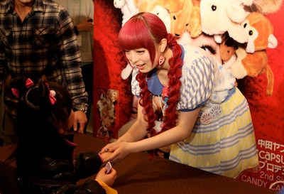 幼い女の子と握手を交わすきゃりーぱみゅぱみゅ。