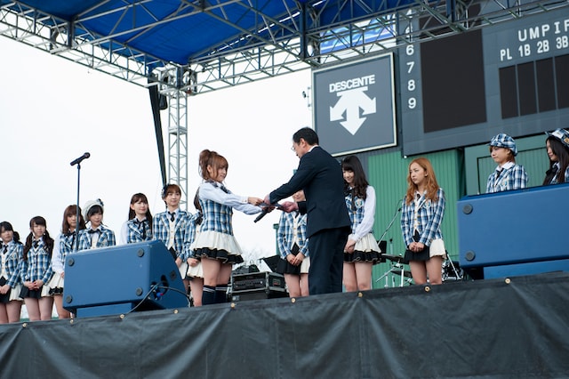 ラッピングバスの目録を平間副町長（写真右）に手渡す高橋みなみ（左）。