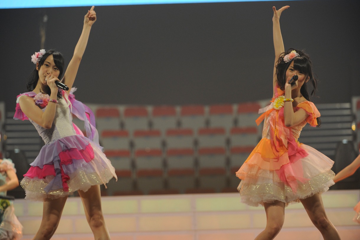 記者会見で「アイシテラブル！」を披露する松井玲奈、高柳明音（写真左から）。 (C)AKS