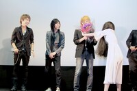 マオに花束を押しつける貞子。