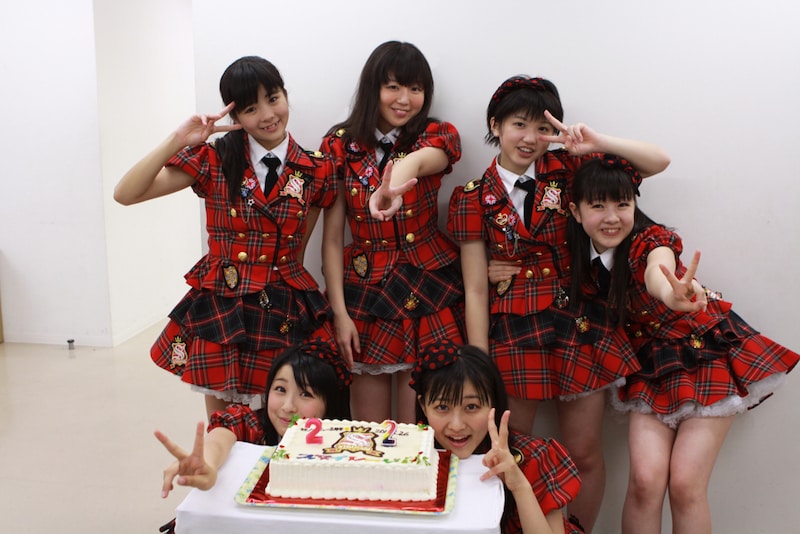ロゴ入りケーキを前に記念撮影するスマイレージ。