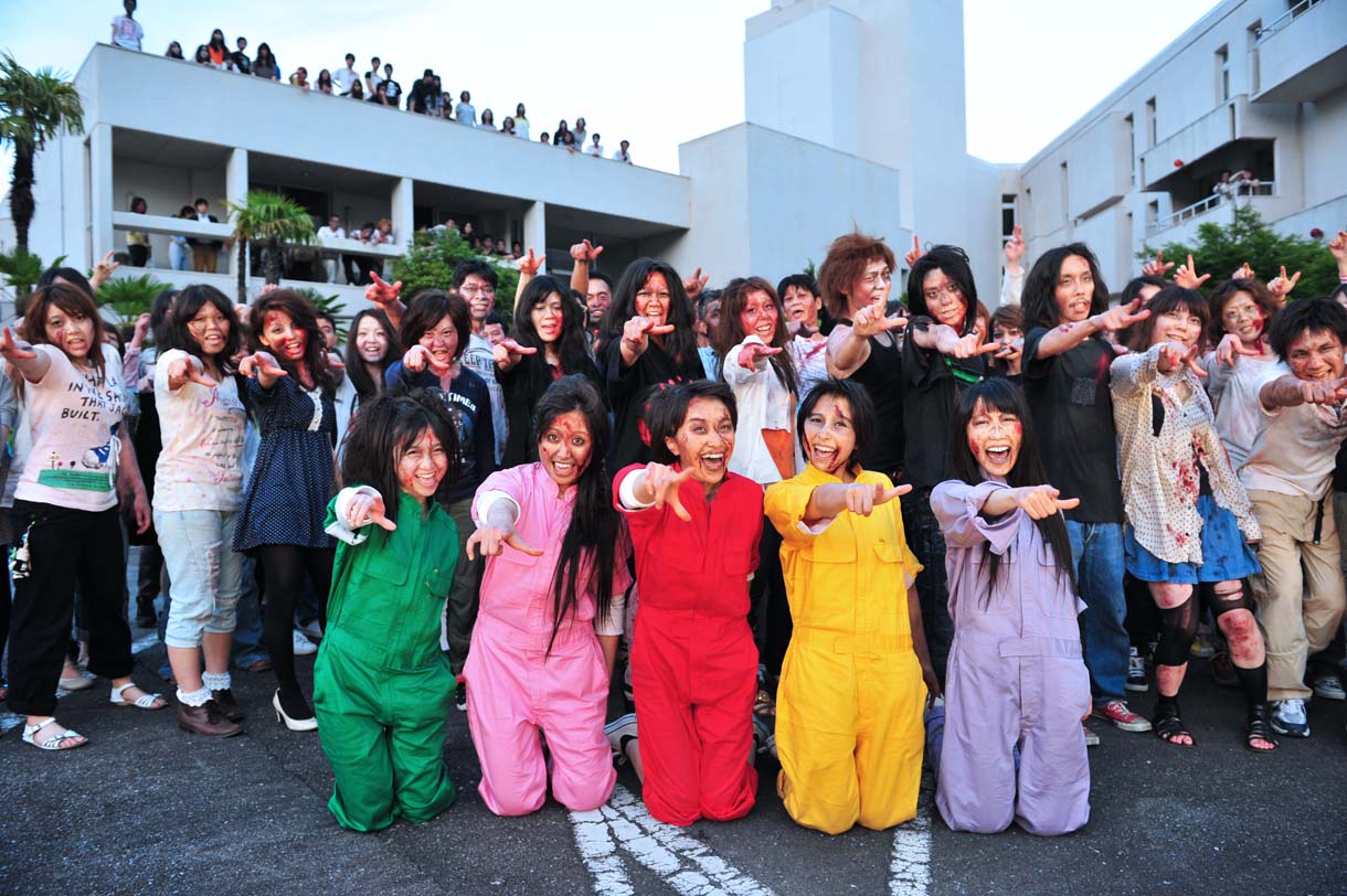 100人のゾンビたちと一緒にZポーズを決めるゾンビメイクのももいろクローバーZ。