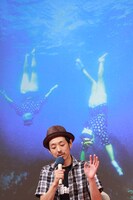 久慈の海に潜る海女をバックに、舞台背景を説明する宮藤。