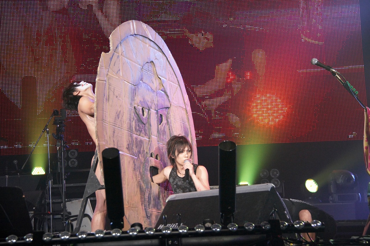 自作の真実の口に手を突っ込む喜矢武豊。その向こうには、パンツ1枚の