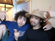 肩を組んでポーズをとるU-zhaan（左）と七尾旅人（右）。