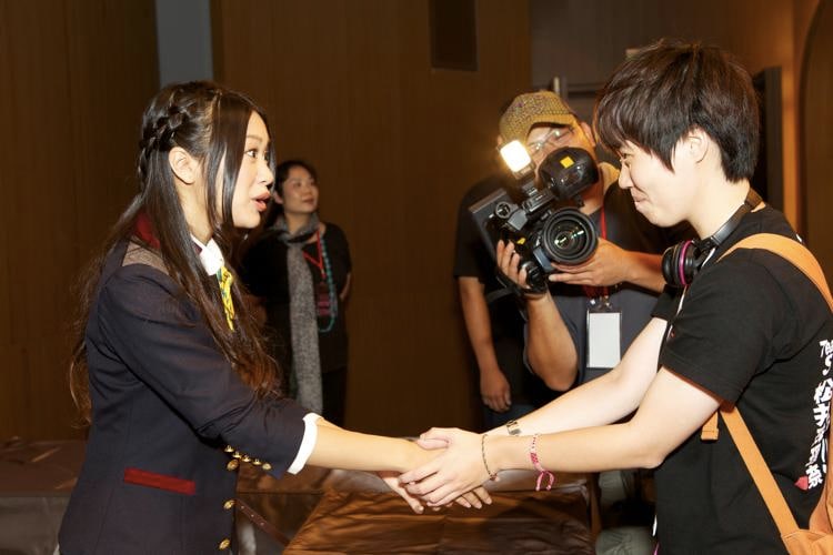 現地のファンと握手を交わす北原里英（写真左）。 (C)AKS