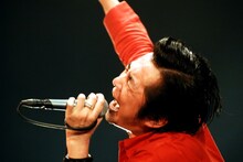 拳を高く突き上げて熱唱する増子直純（Vo）。