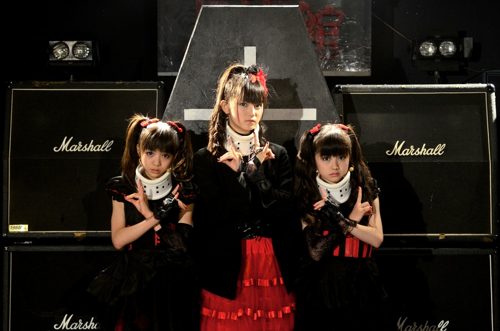 ステージセットの前で記念撮影をするBABYMETAL。（Photo : Taku Fujii）