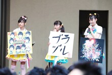 写真は昨日7月22日のステージより。ジャケット拡大パネルを持った鈴木裕乃、柏木ひなた、松野莉奈（左から）。