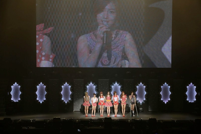 松葉杖をつきながらステージにあがり、ファンに挨拶をするファヨン。