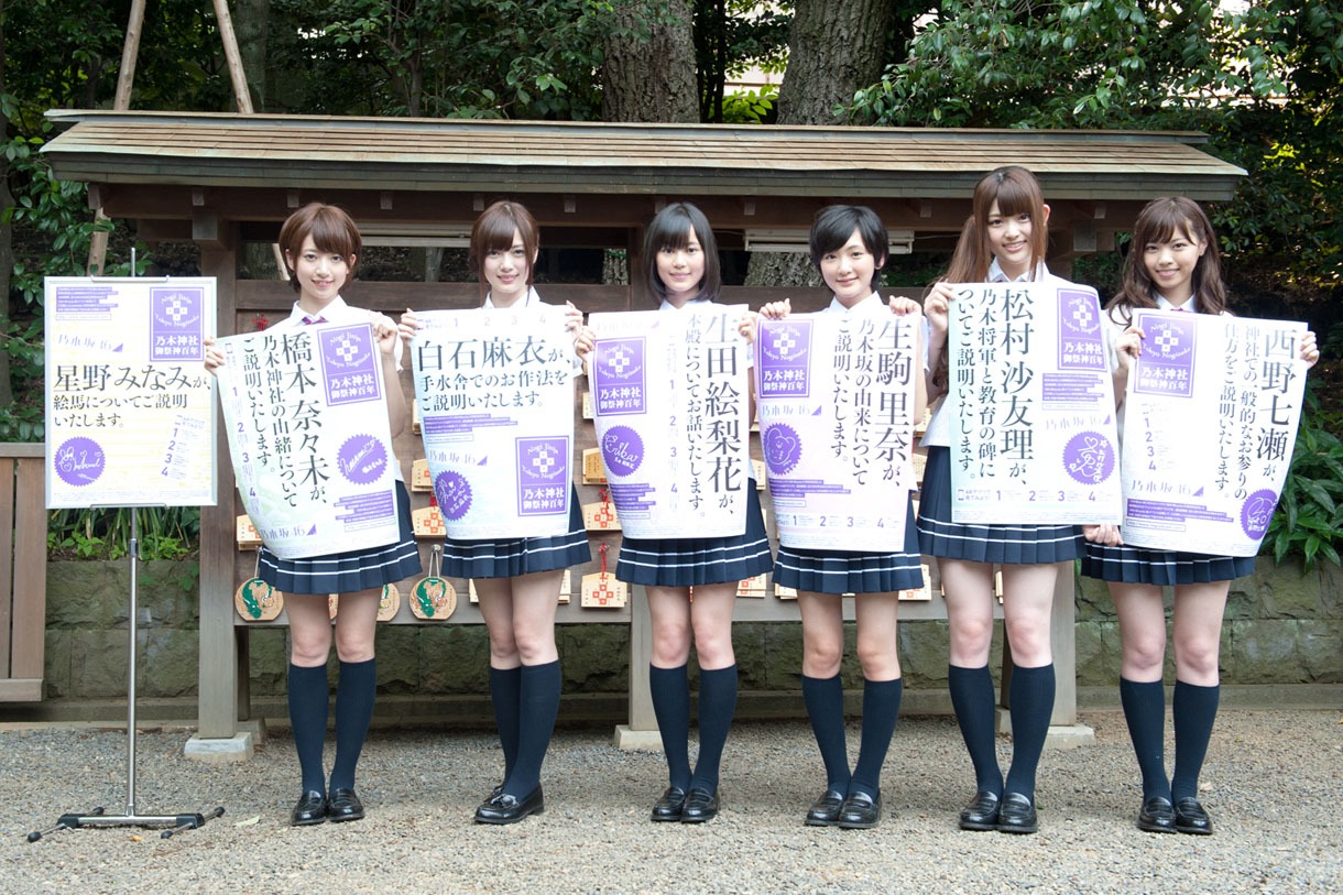 乃木神社境内に設置されるポスターを手に記念撮影する乃木坂46七福神の6名（風邪で欠席の星野みなみを除く）。