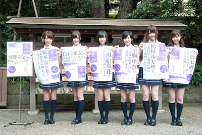 乃木神社境内に設置されるポスターを手に記念撮影する乃木坂46七福神の6名（風邪で欠席の星野みなみを除く）。