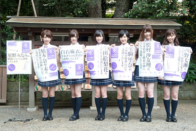 乃木神社境内に設置されるポスターを手に記念撮影する乃木坂46七福神の6名(風邪で欠席の星野みなみを除く)。