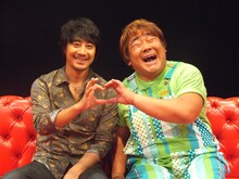 互いの指でハートマークを作る、山崎まさよし（写真左）と石塚英彦（右）。