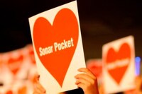 入場時に配布されたハート模様のLPジャケットを高く掲げる観客たち。