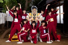 写真は動画撮影中のひとコマ。SHOW-A原寸パネルを囲んでポーズを決めるジャージ姿のエビ中メンバー。