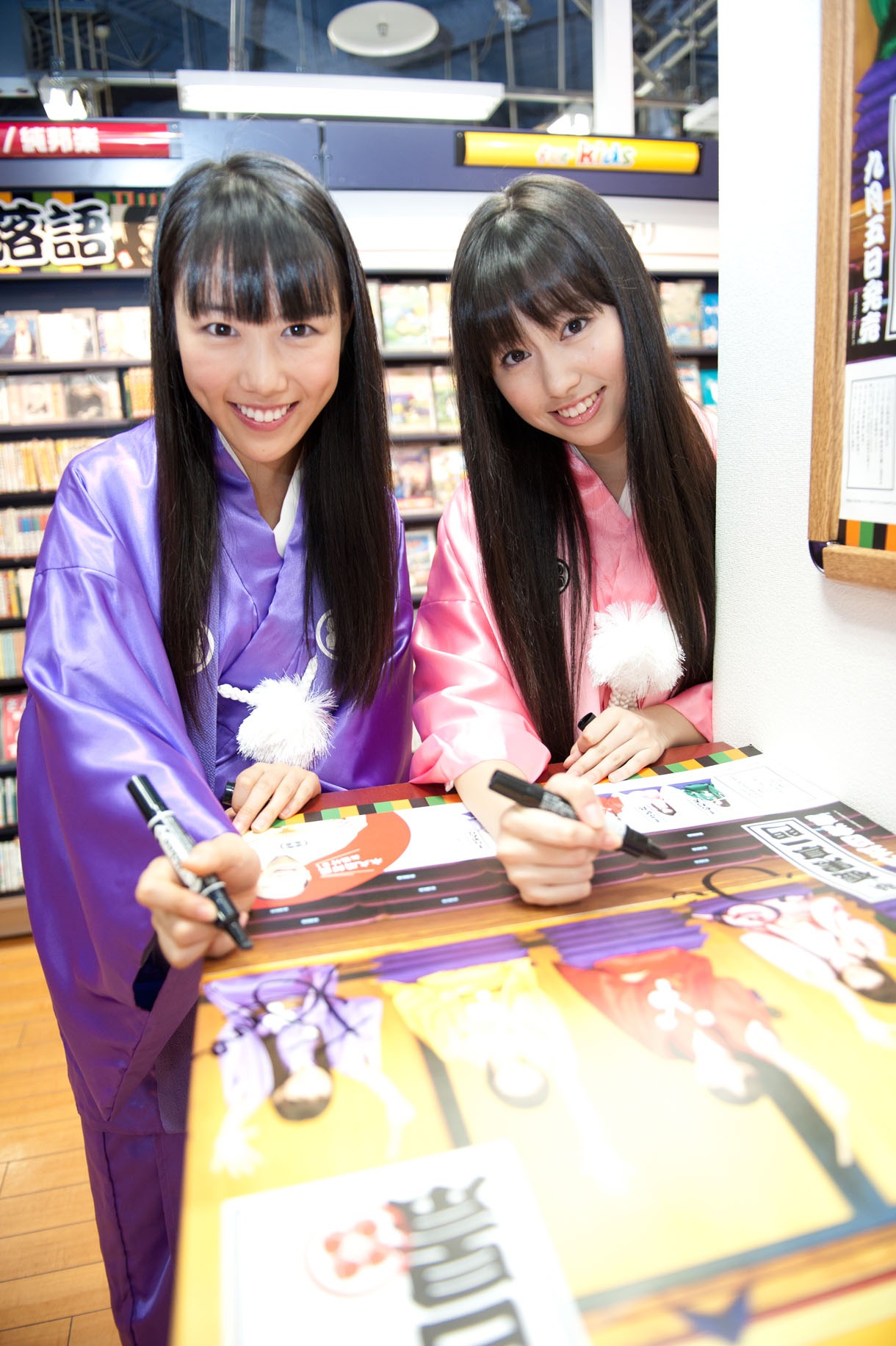 ポスターにサインする桃黒亭なめんな（写真左）とぷに丸（右）。