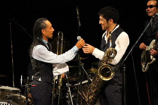 谷中敦（写真右）からマイクを受け取る北原雅彦（写真左）。（Photo by 西田樹）