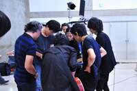 iPadで写真の仕上がりを確認するメンバーとスタッフたち。