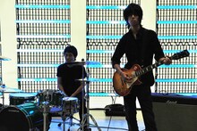 撮影中のヒトコマ。奥が升秀夫（Dr）、手前が増川弘明（G）。